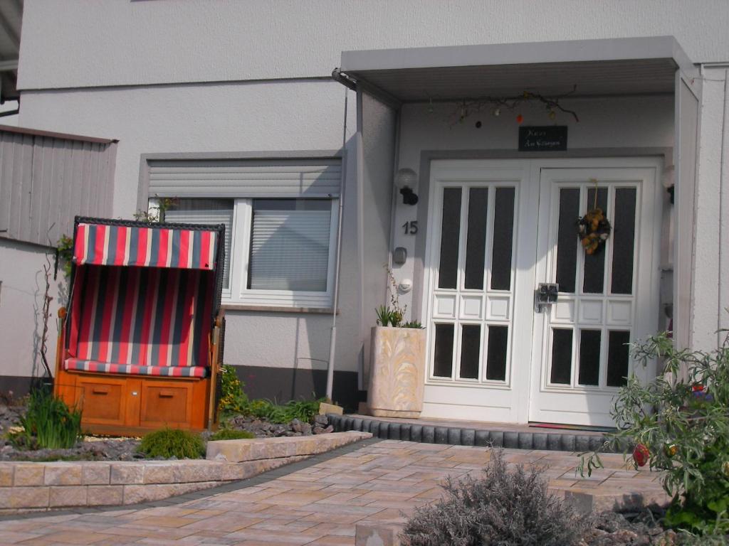 ein Haus mit einer roten und weißen Markise neben einer Tür in der Unterkunft Haus Ellbogen in Momlingen