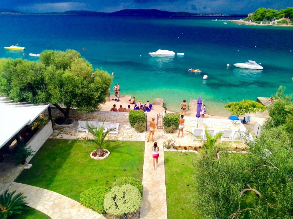 - une vue sur la plage avec des gens dans l'eau dans l'établissement Vila Doni, à Žaborić