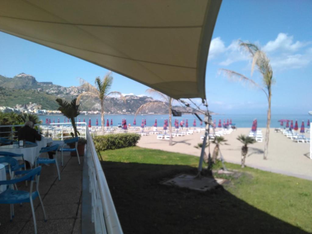vistas a una playa con mesas y sillas en B&B Di Marco, en Giardini Naxos