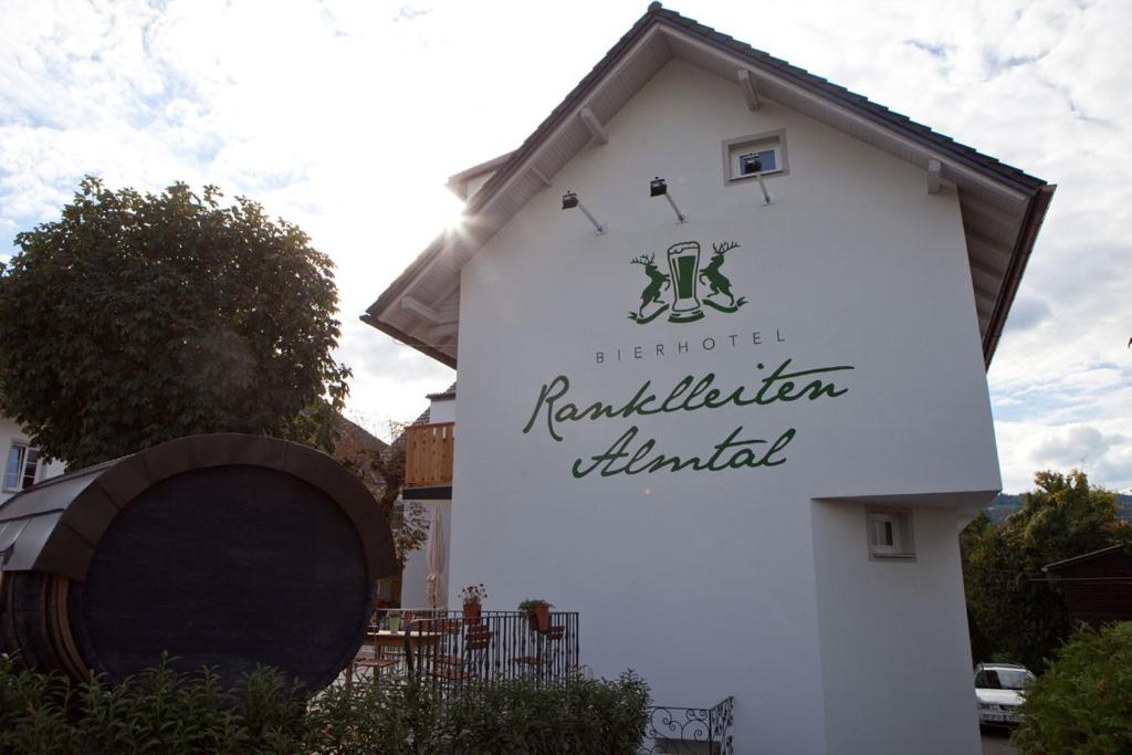 ein weißes Gebäude mit einem Schild für ein rutherfordutherfordtier in der Unterkunft Bierhotel Ranklleiten Almtal in Pettenbach