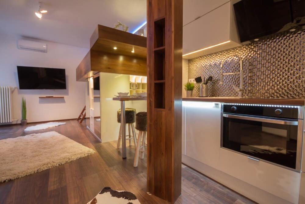 Gold Apartman في بودابست: غرفة معيشة مع مطبخ مع موقد