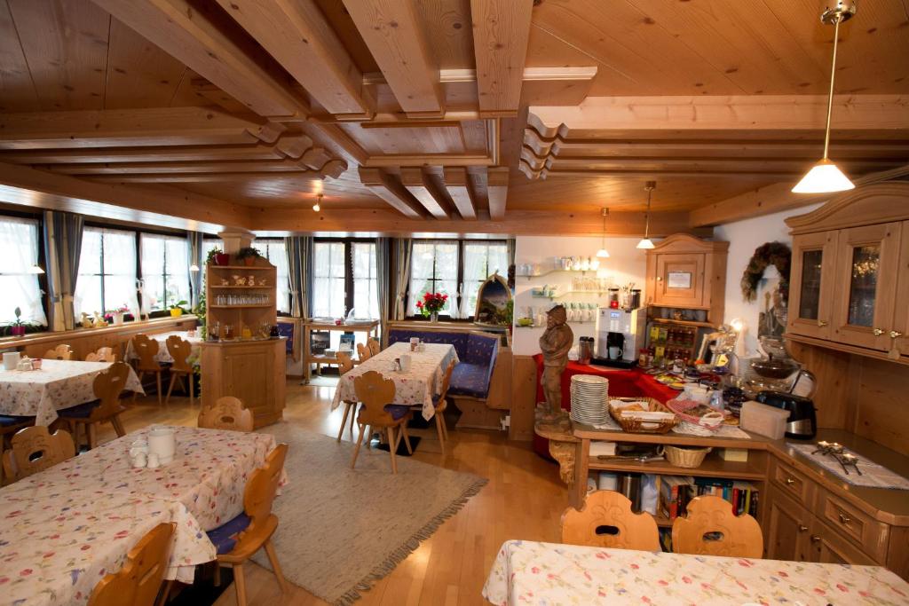 una cucina e una sala da pranzo con tavoli e sedie di Almhof-Reithof Pitztal a Sankt Leonhard im Pitztal