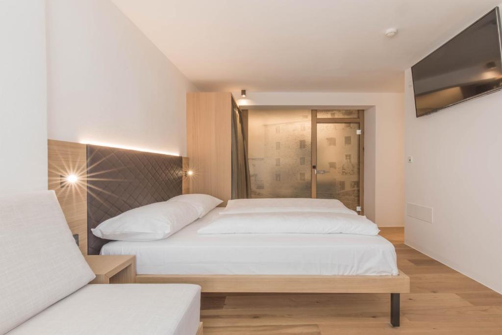 A bed or beds in a room at Belvenu Boutique Hotel