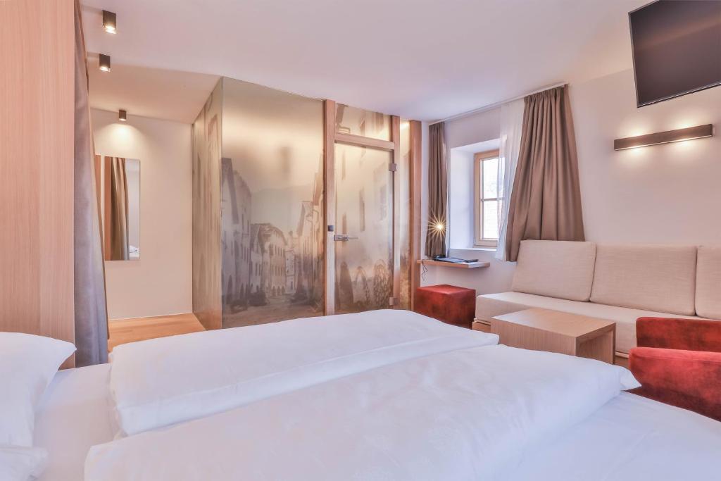 A bed or beds in a room at Belvenu Boutique Hotel