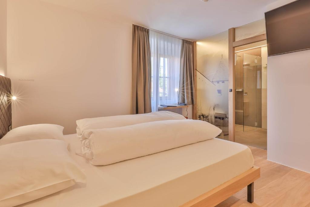 A bed or beds in a room at Belvenu Boutique Hotel