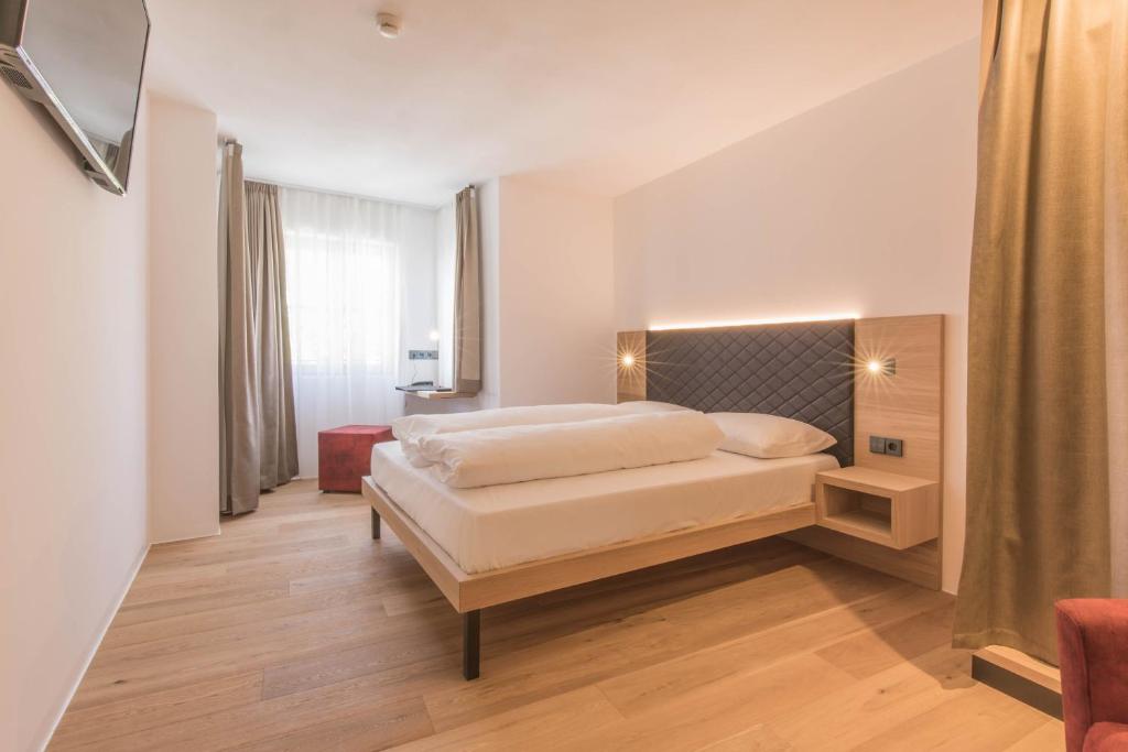 A bed or beds in a room at Belvenu Boutique Hotel