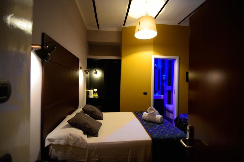 sypialnia z łóżkiem w pokoju z oświetleniem w obiekcie Hotel Felice w Rzymie