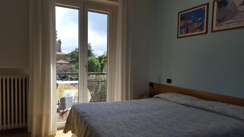 um quarto com uma cama e uma grande janela em Hotel Firenze em Malcesine