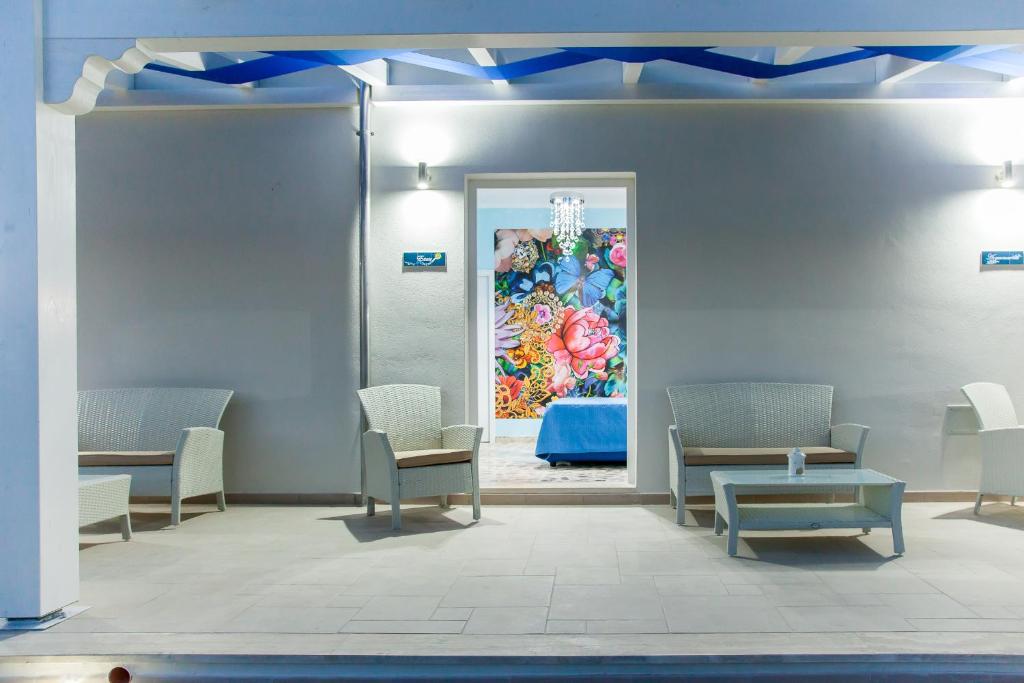 uma sala de espera com cadeiras e um quadro na parede em Blu d'aMare B&B em Porto Cesareo
