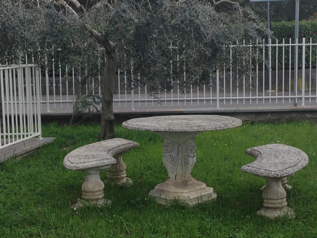un tavolo di pietra e due panche nell'erba di Casa Armonia a Peschiera del Garda
