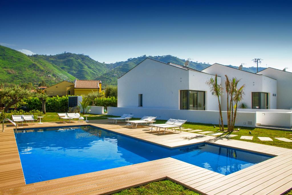 a villa with a swimming pool and a house at Baia degli Ulivi Apartments in Cefalù