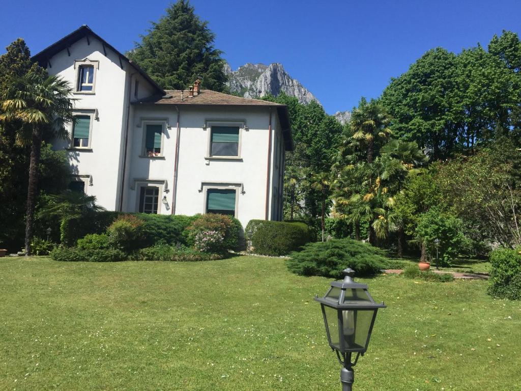 a white house with a street light in front of it at Villa del Cigno in Lecco