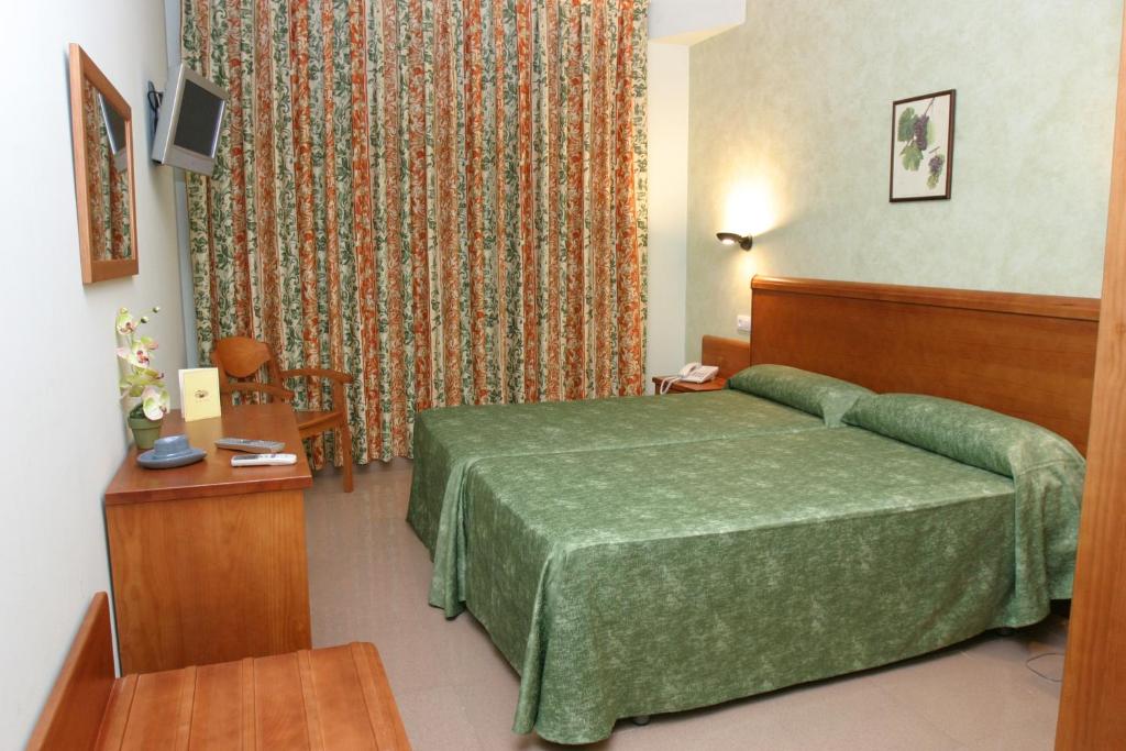 En eller flere senge i et værelse på Hotel Fonda Neus