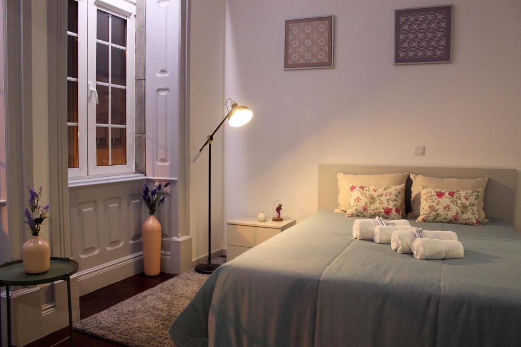 een slaapkamer met een bed met handdoeken erop bij Charme e Alegria in Viseu