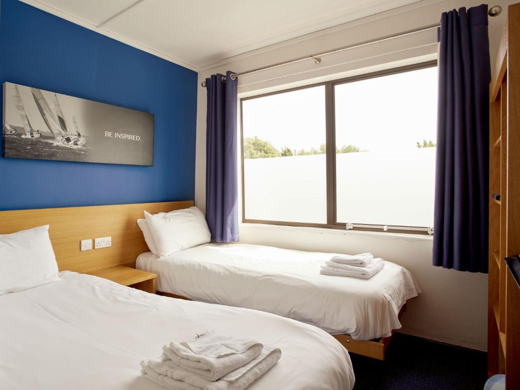 two beds in a room with a window at Holme Pierrepont Country Park Home of The National Water Sports Centre in Nottingham