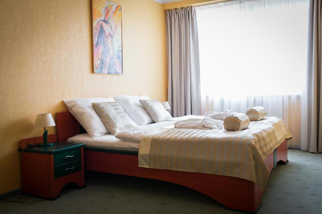 A bed or beds in a room at Hotel Kormorán