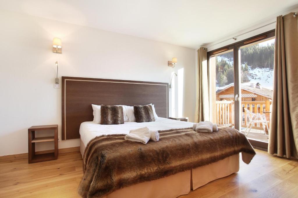 Postel nebo postele na pokoji v ubytování Hôtel Prestige Odalys Le Chamois