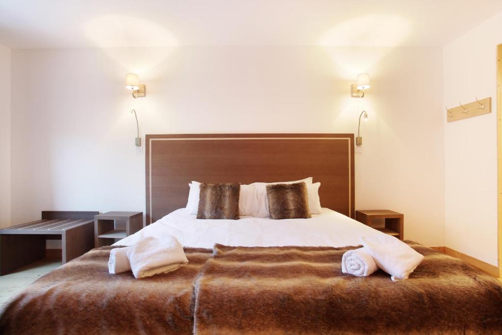 Postel nebo postele na pokoji v ubytování Hôtel Prestige Odalys Le Chamois
