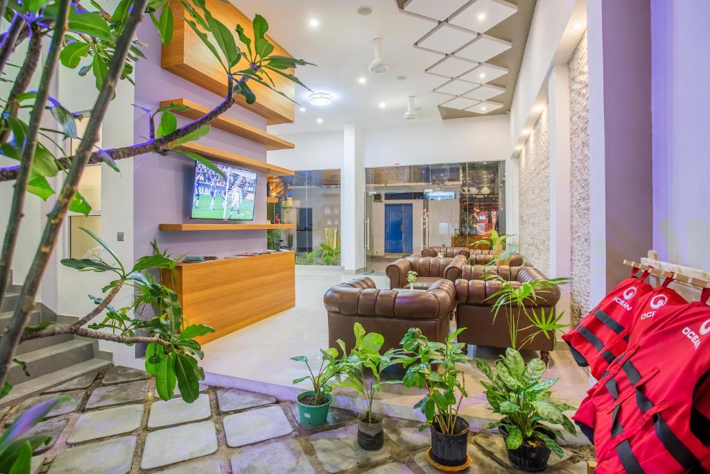 a lobby with couches and potted plants at Kuredhi Beach Inn in Maafushi