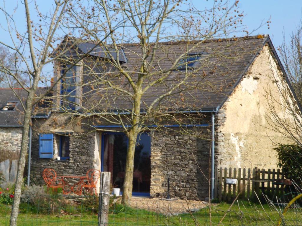 ein altes Steinhaus mit einem Baum im Hof in der Unterkunft La Guichardière in Vay