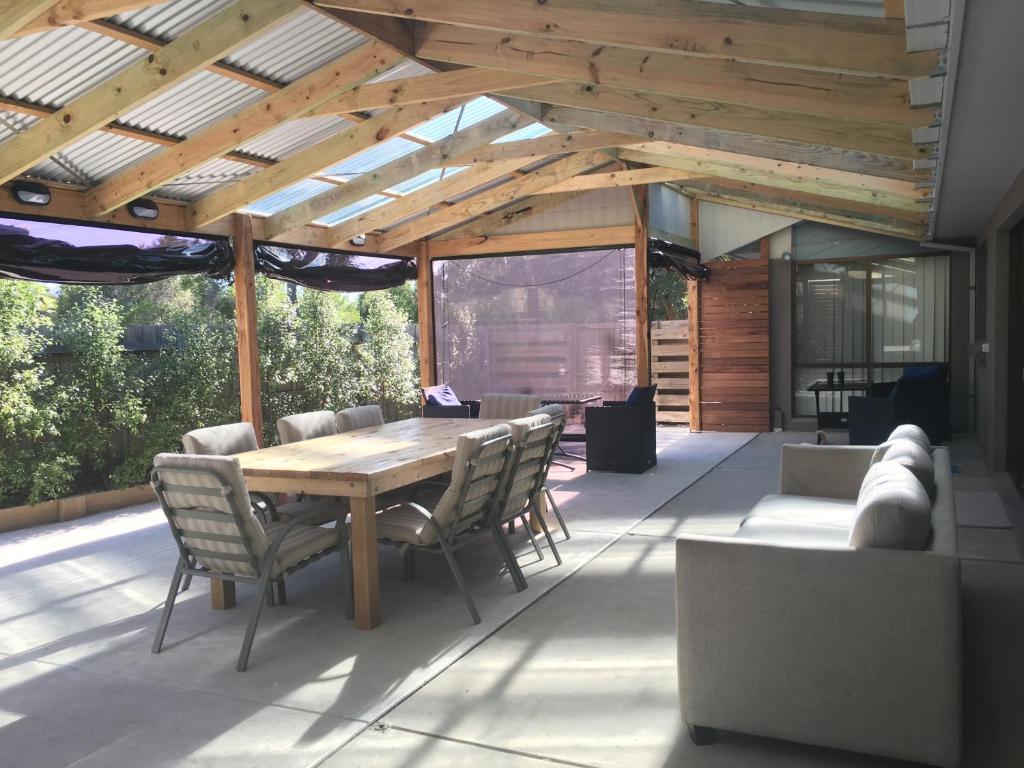 a patio with a wooden ceiling and a table and chairs at Beach House Getaway 2 in Smiths Beach