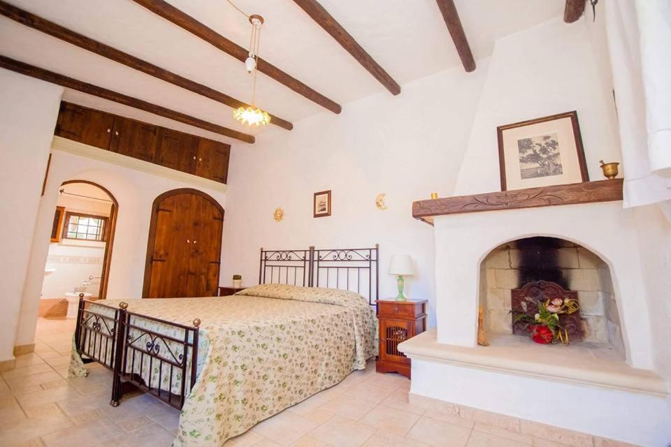 1 dormitorio con 1 cama y chimenea en Masseria Borgo del Gallo, en Tricase