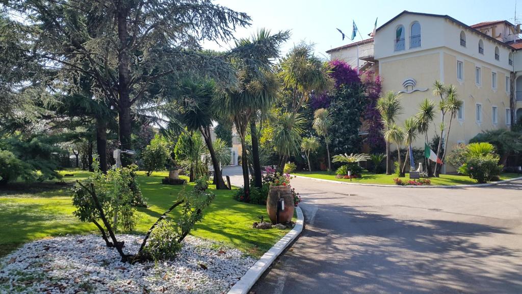 una calle con palmeras y un edificio en Hotel Mediterraneo, en Qualiano