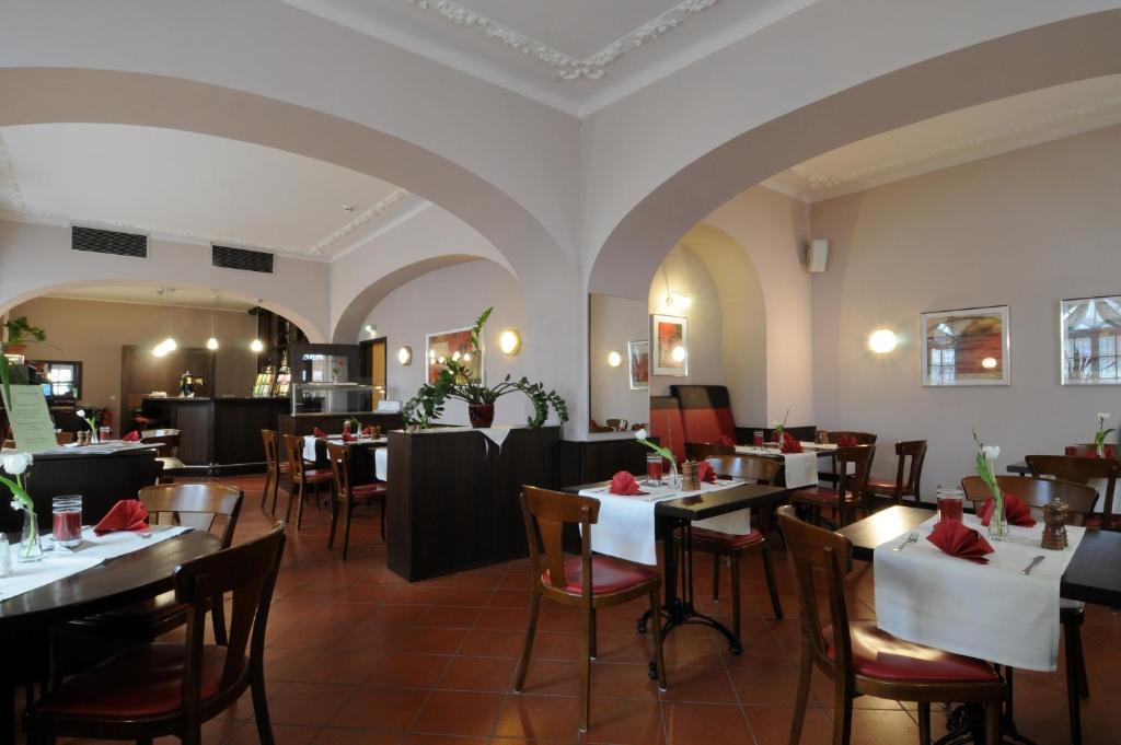 un restaurante con mesas y sillas en una habitación en Hotel Döbelner Hof, en Döbeln