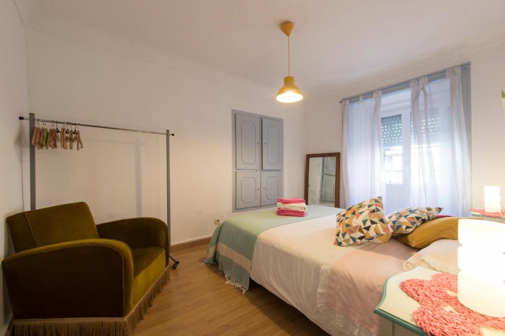 een slaapkamer met 2 bedden, een stoel en een raam bij Downtown Doll's House in Lissabon