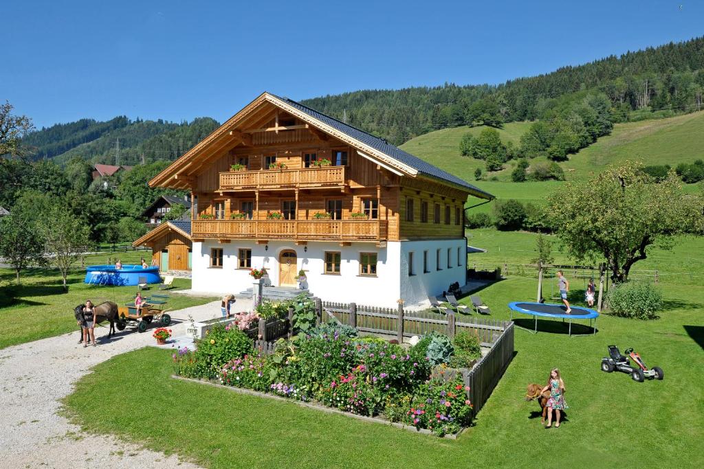 a large wooden house with people in front of it at Apartment Hinkerhof in Schladming