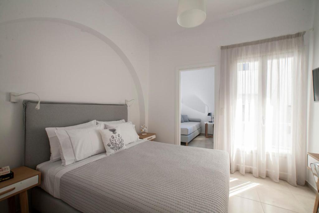- une chambre avec un lit et une grande fenêtre dans l'établissement Aelia Apartments, à Naxos Chora