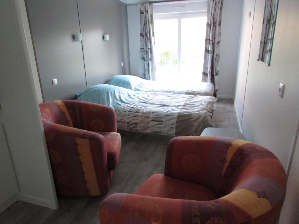 Etretat's Motel في إتريتا: غرفة بها كرسيين وسرير ونافذة