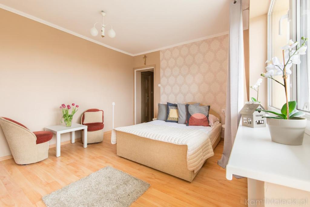 a bedroom with a bed and chairs in a room at Dom Gościnny Marta in Krynica Morska