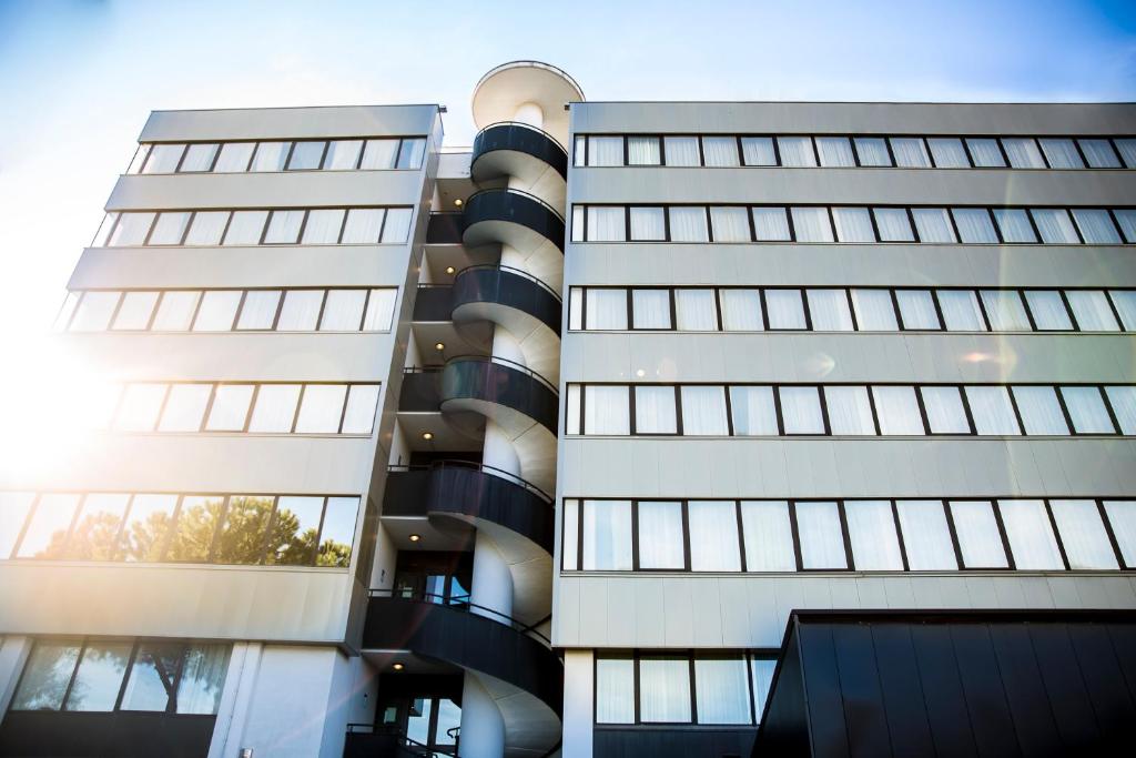 twee hoge gebouwen met de zon in de ramen bij The Caesar Roma in Rome