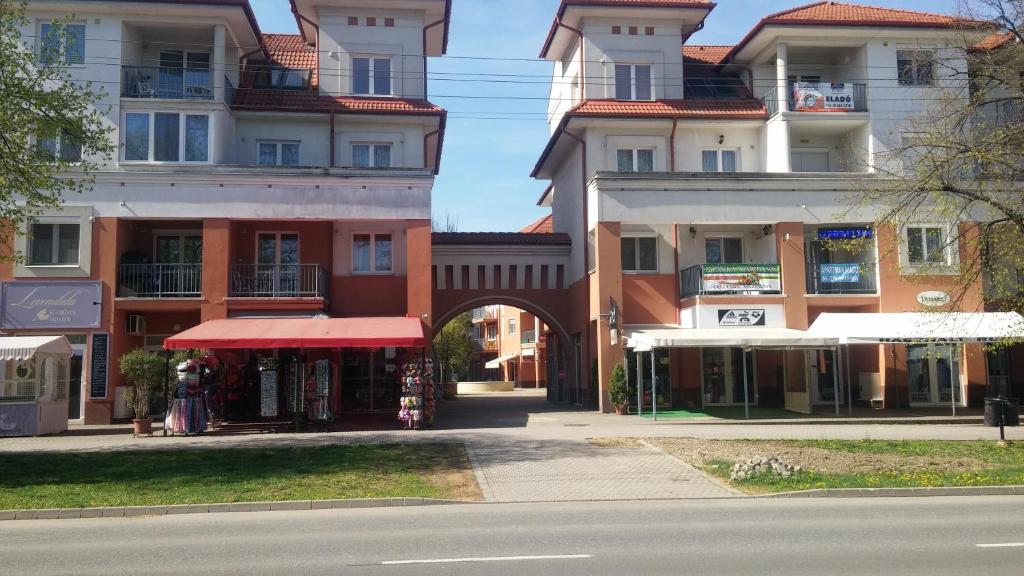un grupo de edificios con un arco en una calle en Baby Apartman en Hajdúszoboszló