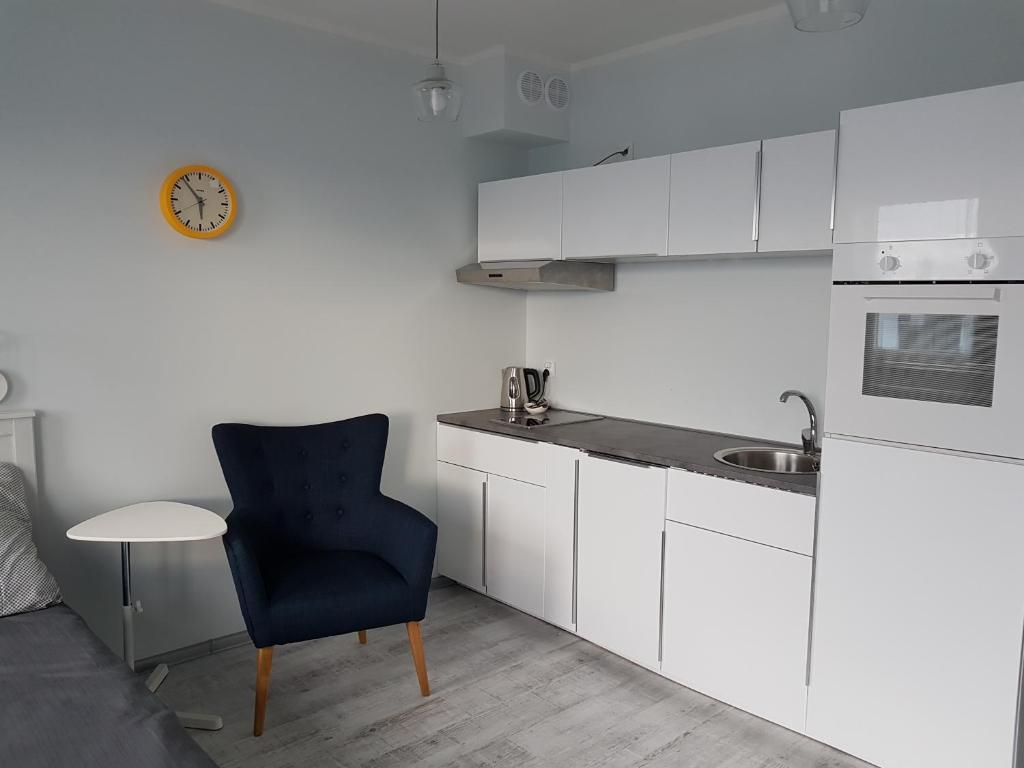a kitchen with a blue chair and a sink at Cukrownia in Szczecin
