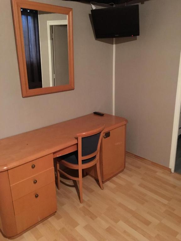 a desk with a mirror and a chair in a room at Les Lilas Des Deux Ponts in Cravant