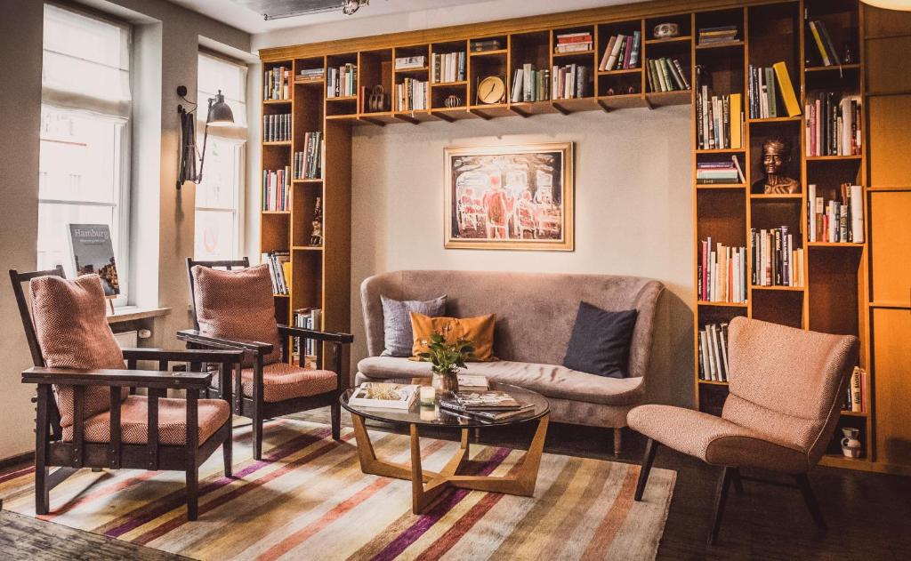 a living room filled with furniture and a bookcase at Henri Hotel Hamburg Downtown in Hamburg