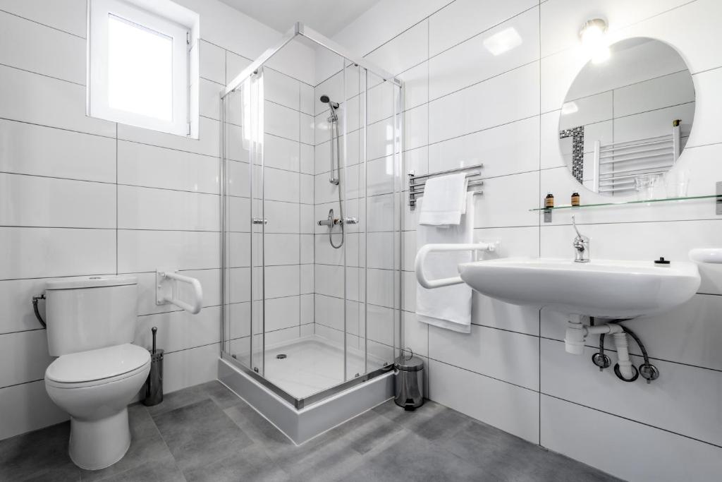 a bathroom with a toilet and a sink and a shower at L26 Łopuszańska in Warsaw