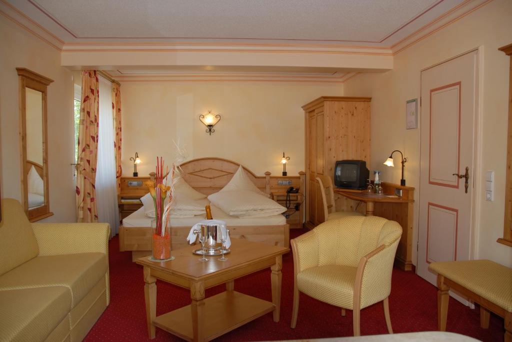 ein Wohnzimmer mit einem Bett, einem Sofa und einem Tisch in der Unterkunft Hotel-Restaurant Schieble in Kenzingen