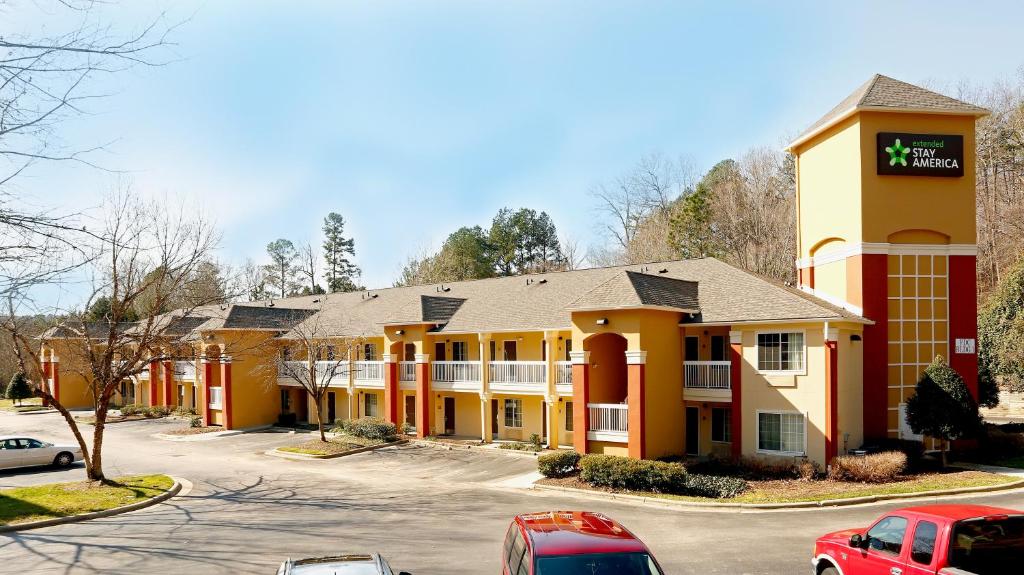 a hotel with cars parked in front of a parking lot at Suburban Studios in Raleigh