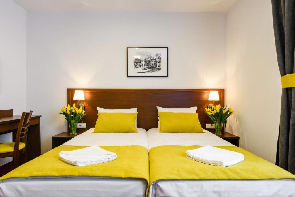 - une chambre avec un lit doté de draps jaunes et d'oreillers jaunes dans l'établissement L26 Łopuszańska, à Varsovie