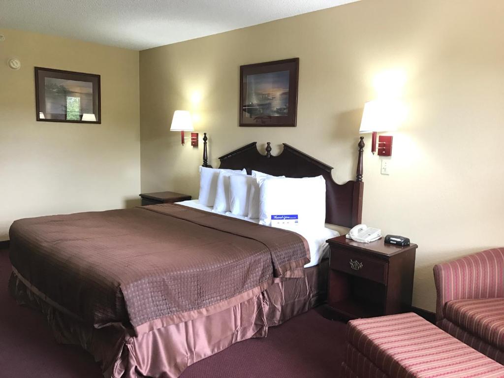 um quarto de hotel com uma cama e uma cadeira em Americas Best Value Inn & Suites - Little Rock - Maumelle em Maumelle