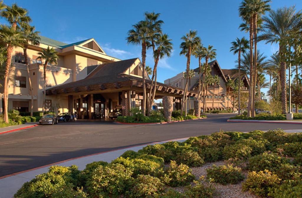 a building with palm trees in front of a street at Tahiti Village Resort & Spa in Las Vegas