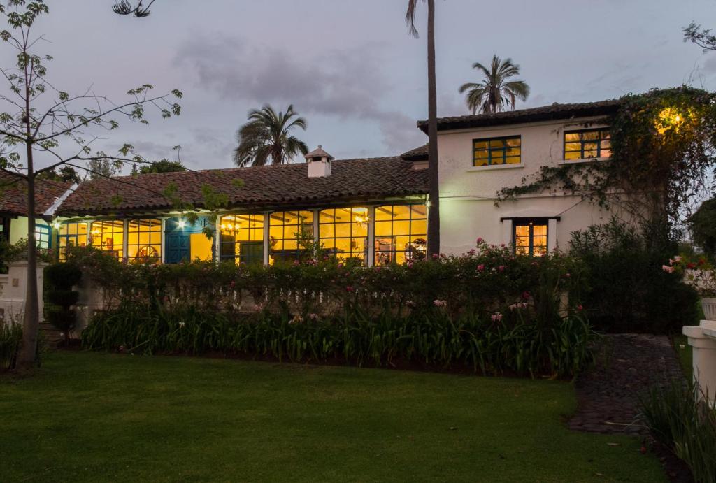 a house with a lot of windows in a yard at Hotel Boutique Casa de Hacienda Su Merced in Puembo