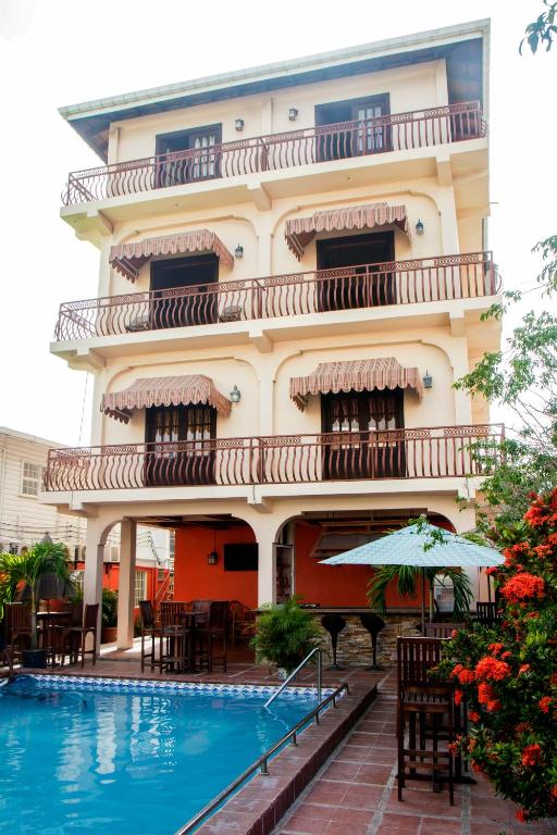 a hotel with a swimming pool in front of a building at Windjammer International Cuisine & Comfort Inn in Georgetown