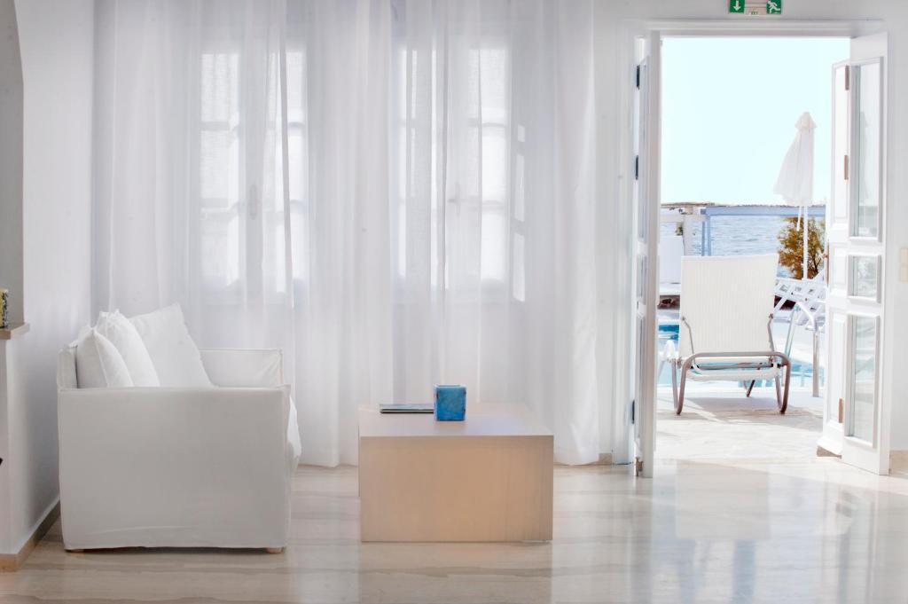 un soggiorno con mobili bianchi e tavolo di Poseidon Beach Hotel a Kamari