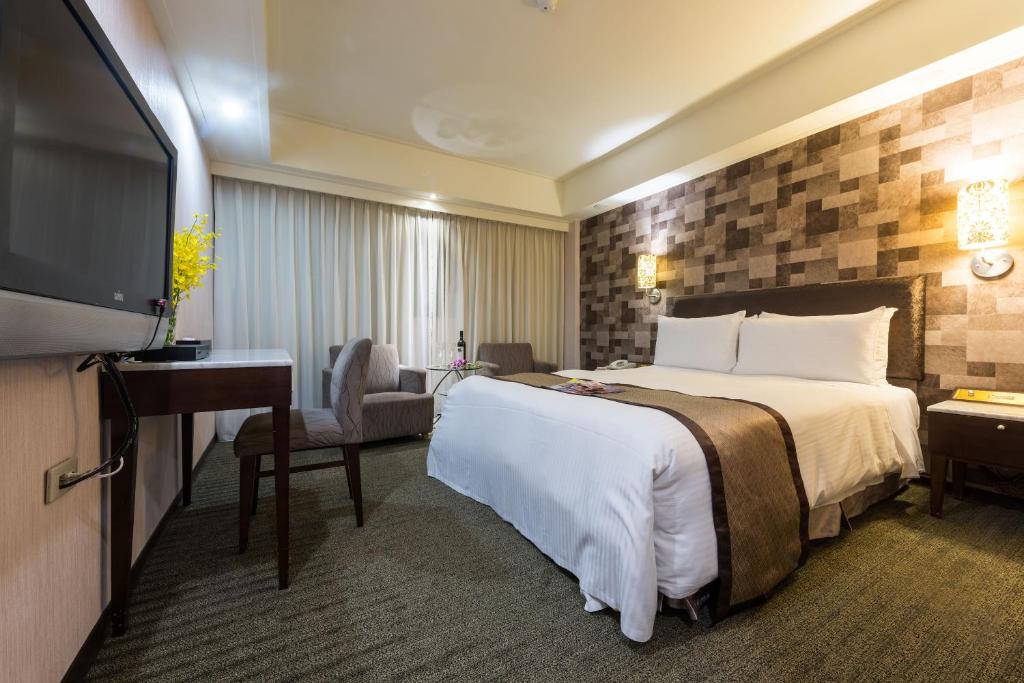 Habitación de hotel con cama y TV de pantalla plana. en Forward Suites Ⅰ, en Taipéi