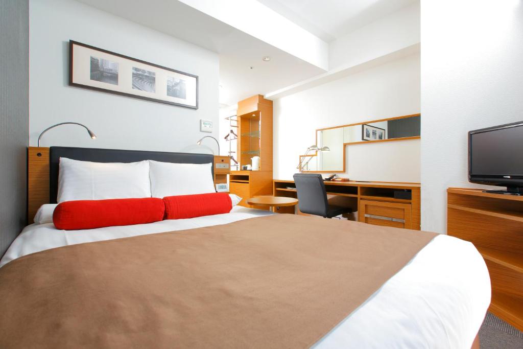 a hotel room with a bed and a desk and a tv at HOTEL MYSTAYS Kamata in Tokyo