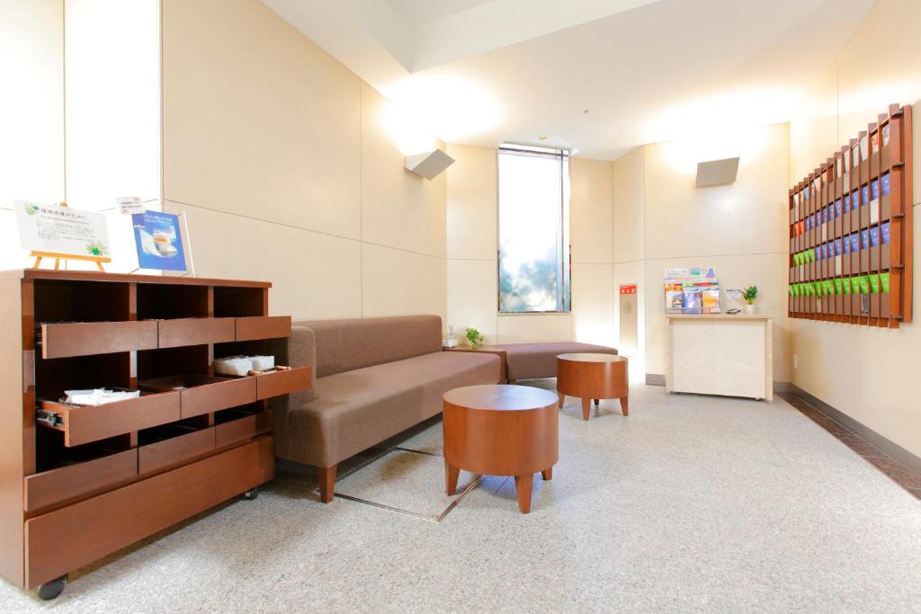 a living room with a couch and a table at HOTEL MYSTAYS Kamata in Tokyo